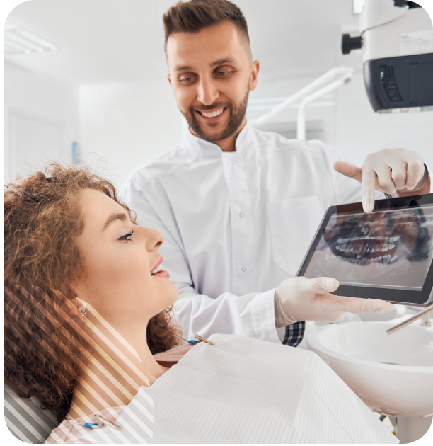 Dentist showing dental x-ray to female patient on a tablet in a modern dental clinic.